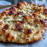 Warm The Best Easy Garlic Naan Bread served alongside a rich curry, perfect for scooping.