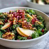 Vibrant vegetarian Kale and Pomegranate Bowl garnished with chopped nuts, served in a rustic white bowl for a healthy lunch.