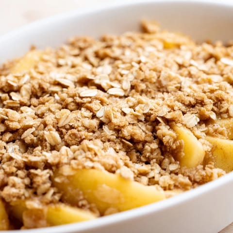 Freshly baked Apple Crumble with golden, buttery crumbs bubbling over tender spiced apples, ready to serve.