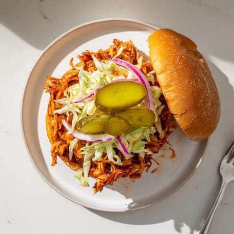 Juicy BBQ Chicken Sandwich stacked with pickles and onions, ready to serve with golden fries.