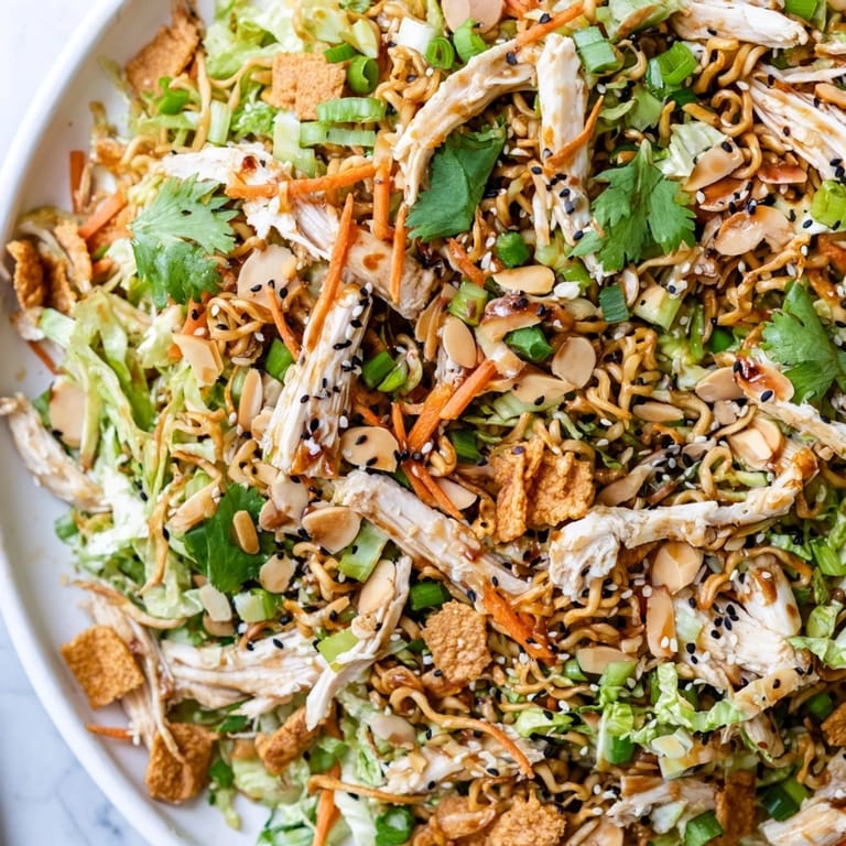 This American-Asian fusion salad features crunchy almonds, fresh scallions, and a vibrant mix of cabbage and carrots, perfect for potlucks.